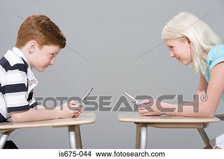 Girl and boy using mobile phones View Large Photo Image Picture - Girl and boy using mobile phones. Fotosearch