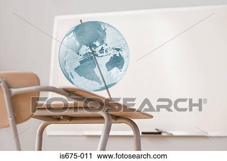 Stock Image - Globe and desk in a classroom. Fotosearch
