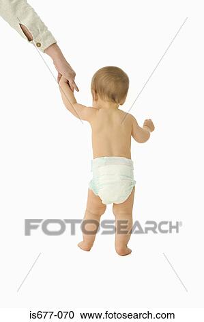 Stock Image - Adult helping baby to walk. Fotosearch
