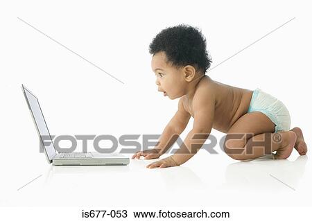Stock Image - Baby fascinated by laptop computer. Fotosearch