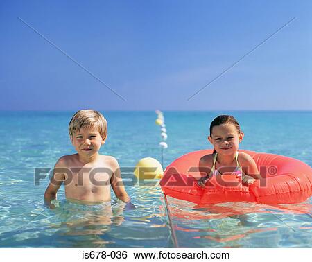 Stock Photograph - Boy and girl in the sea. Fotosearch