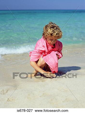 Boy playing in the sand View Large Photo Image Stock Photo - Boy playing in the sand. Fotosearch