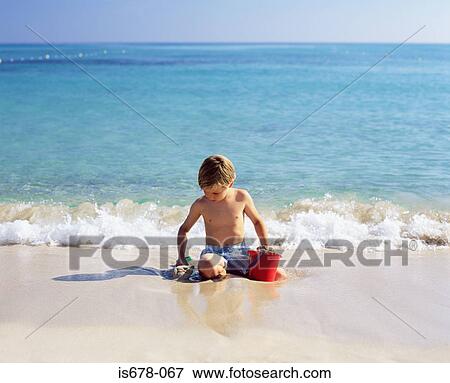 Boy playing with wet sand View Large Photo Image Stock Photo - Boy playing with wet sand. Fotosearch