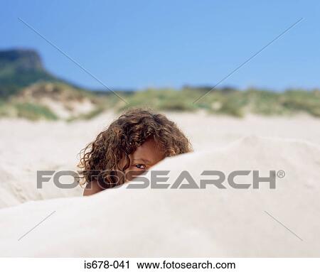 Stock Image - Girl hiding in the sand. Fotosearch