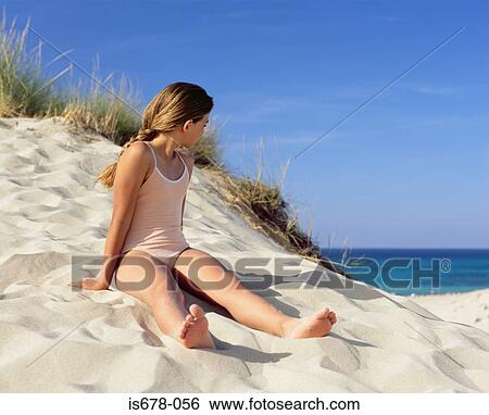 Girl sitting on a sand dune View Large Photo Image Stock Photograph - Girl sitting on a sand dune. Fotosearch