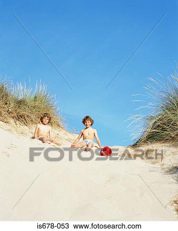 Stock Image - Twin boys in a sand dune. Fotosearch