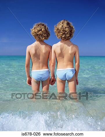 Twin boys standing in the sea View Large Photo Image Stock Photograph - Twin boys standing in the sea. Fotosearch
