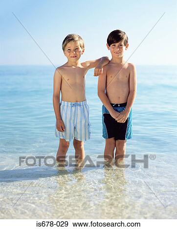 Two boys standing in the sea View Large Photo Image Stock Photo - Two boys standing in the sea. Fotosearch
