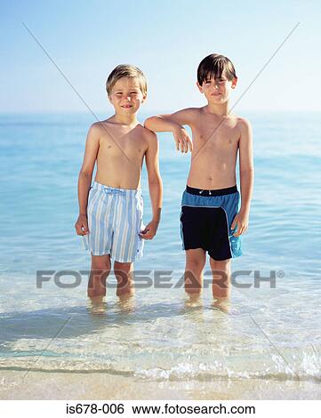Two boys standing in the sea View Large Photo Image Stock Photograph - Two boys standing in the sea. Fotosearch
