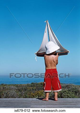 Boy holding a toy boat View Large Photo Image Stock Image - Boy holding a toy boat. Fotosearch