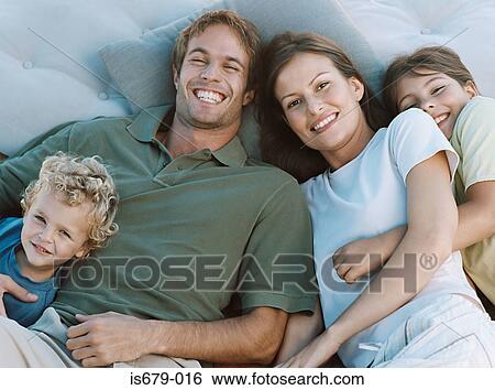 Stock Photograph - Family lying on cushions. Fotosearch
