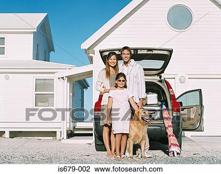 Stock Image - Family standing by their car. Fotosearch
