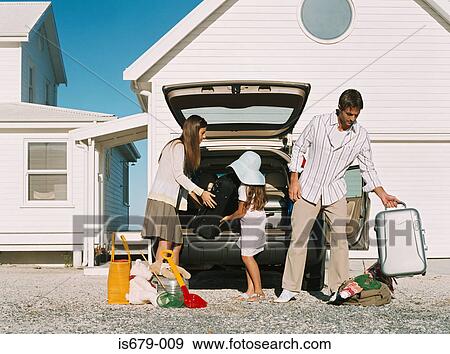 Family unpacking luggage from the car View Large Photo Image Stock Photo - Family unpacking luggage from the car. Fotosearch
