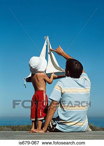 Father and son with toy boat View Large Photo Image Stock Photo - Father and son with toy boat. Fotosearch