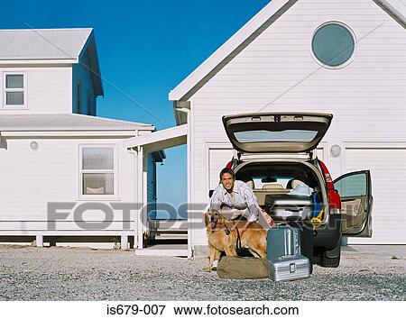 Stock Photo - Man by his car with pet dog. Fotosearch