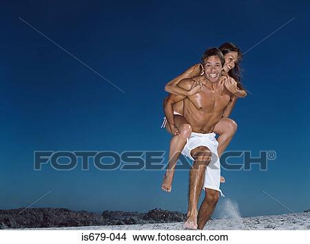 Picture - Man giving wife a piggyback. Fotosearch