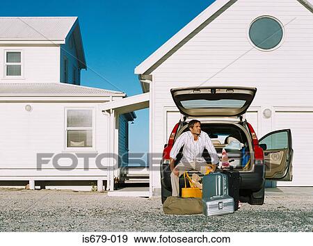 Stock Photo - Man resting on his car boot. Fotosearch