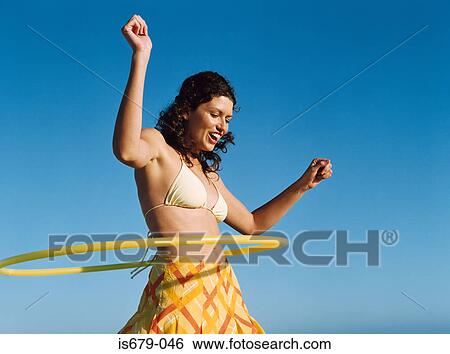 Woman playing with hula hoop View Large Photo Image Stock Photograph - Woman playing with hula hoop. Fotosearch