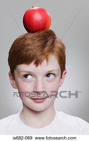 Boy balancing an apple on his head View Large Photo Image Stock Photo - Boy balancing an apple on his head. Fotosearch