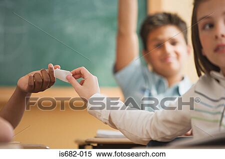 Stock Photography - Girl passing a note in class. Fotosearch