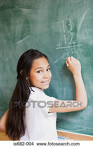 Girl writing a sum on a blackboard View Large Photo Image Picture - Girl writing a sum on a blackboard. Fotosearch