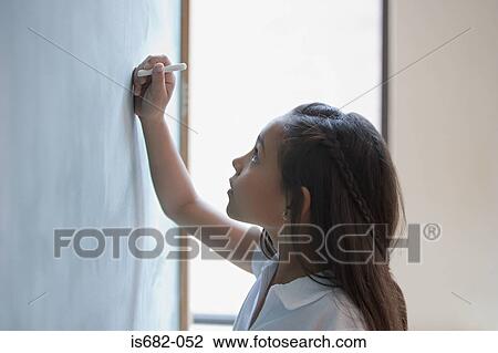 Girl writing a sum on a blackboard View Large Photo Image Stock Image - Girl writing a sum on a blackboard. Fotosearch