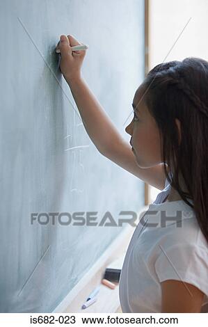 Girl writing on a blackboard View Large Photo Image Stock Image - Girl writing on a blackboard. Fotosearch