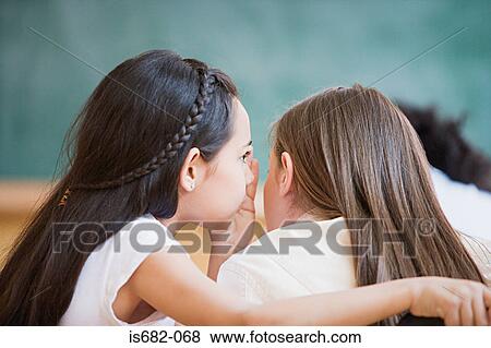 Stock Photo - Girls whispering in class. Fotosearch