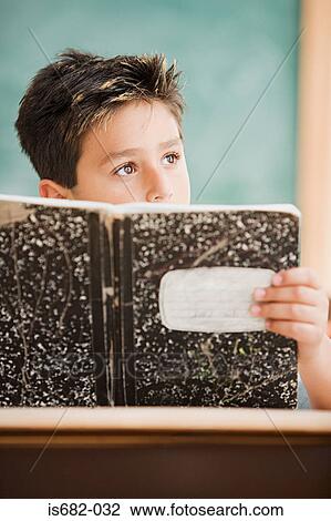 Stock Image - Schoolboy holding a textbook. Fotosearch