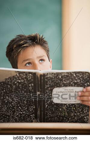 Schoolboy holding a textbook View Large Photo Image Stock Photo - Schoolboy holding a textbook. Fotosearch