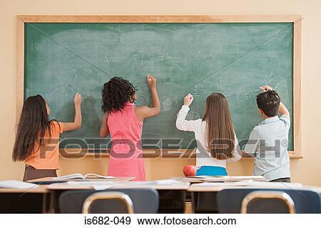 Schoolchildren writing on a blackboard View Large Photo Image Stock Photo - Schoolchildren writing on a blackboard. Fotosearch