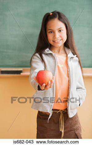Stock Image - Schoolgirl holding an apple. Fotosearch