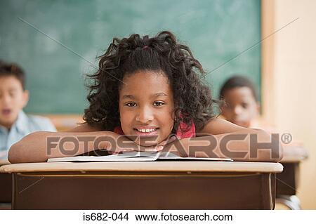 Picture - Schoolgirl leaning on desk. Fotosearch