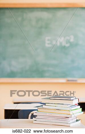 Stock Image - Textbooks and blackboard in classroom. Fotosearch