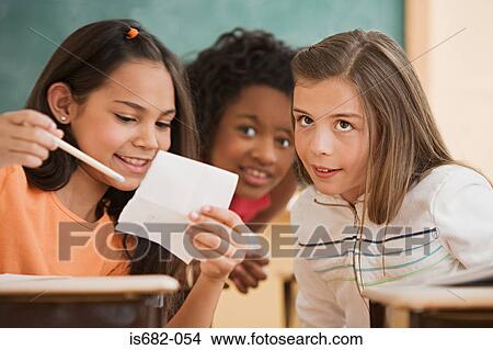 Three girls reading a note View Large Photo Image Picture - Three girls reading a note. Fotosearch
