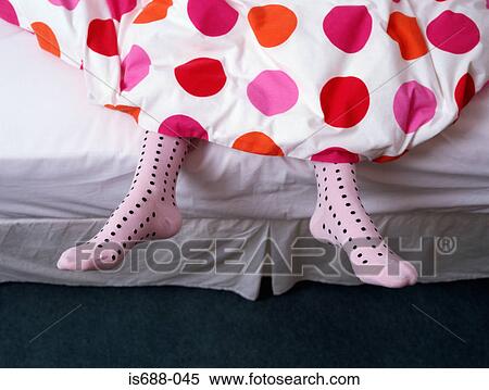 Stock Photography - Feet dangling out of bed. Fotosearch