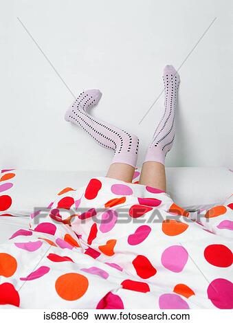 Legs in socks poking out of bed View Large Photo Image Stock Photo - Legs in socks poking out of bed. Fotosearch