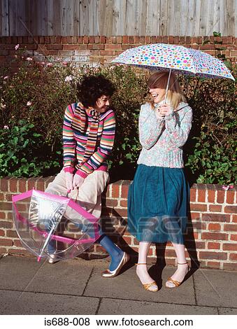 Two friends with umbrellas View Large Photo Image Stock Photo - Two friends with umbrellas. Fotosearch