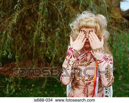 Woman in garden covering eyes View Large Photo Image Picture - Woman in garden covering eyes. Fotosearch
