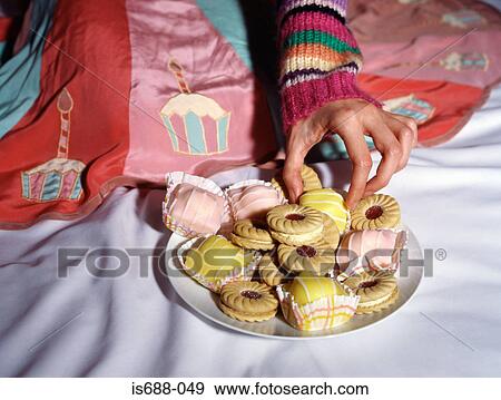 Woman taking a cake from a plate View Large Photo Image Stock Photo - Woman taking a cake from a plate. Fotosearch