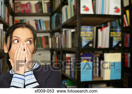 Shocked young woman in library View Large Photo Image Stock Image - Shocked young woman in library. Fotosearch