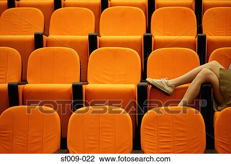Stock Image - Woman's legs in a lecture theatre. Fotosearch
