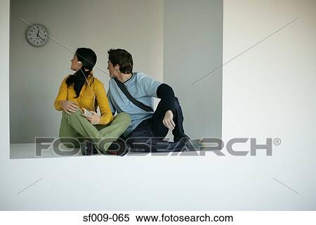 Young couple listening to music on a break View Large Photo Image Stock Photography - Young couple listening to music on a break. Fotosearch