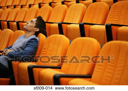 Young man alone in lecture theatre View Large Photo Image Picture - Young man alone in lecture theatre. Fotosearch