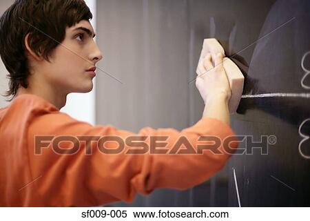 Stock Photography - Young man wiping a blackboard. Fotosearch
