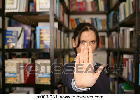 Stock Image - Young woman putting her hand up. Fotosearch
