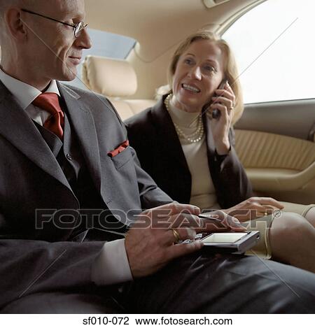 Stock Image - Business people in a taxi. Fotosearch