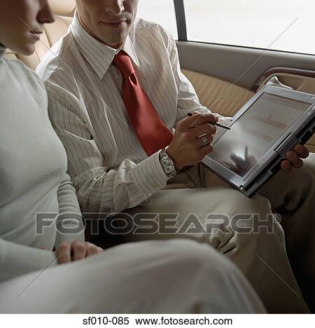 Business people using laptop in taxi View Large Photo Image Stock Photography - Business people using laptop in taxi. Fotosearch