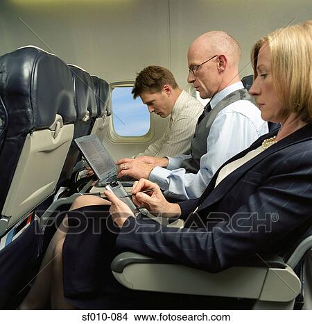 Picture - Business people working in an aeroplane. Fotosearch