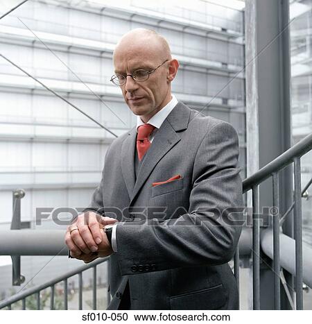Stock Image - Businessman looking at his watch. Fotosearch
